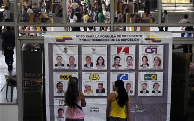Women look at banner serving as a sample ballot displaying candidates outside a polling station during presidential elections in Medellin, Colombia, on Sunday.